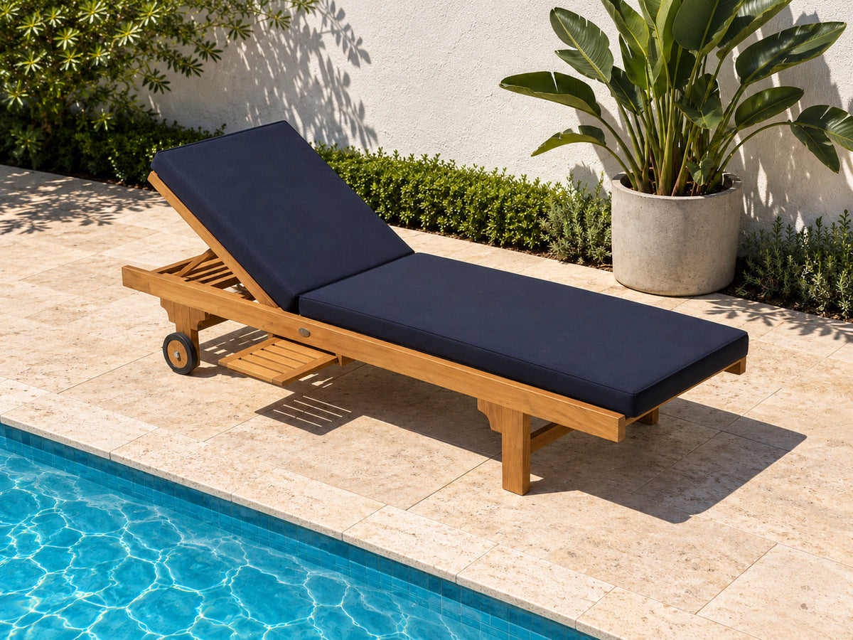 Extra Wide teak pool lounge with a navy cushion on travertine paving beside a pool
