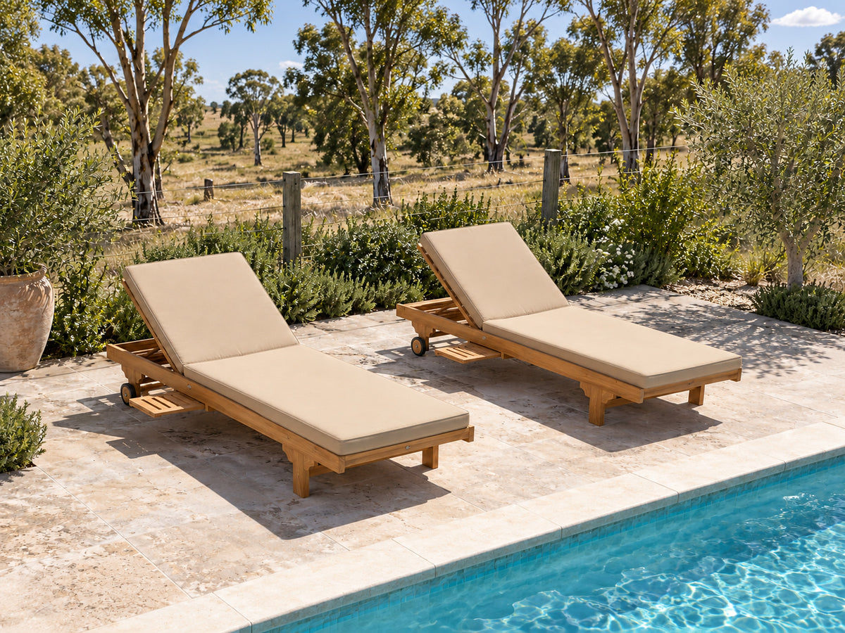Two Extra Wide teak pool lounges with oatmeal cushions beside a pool in a country garden