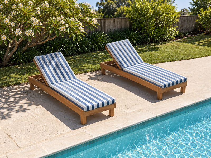 Two Portsea teak pool lounges with blue and white stripe cushions beside a backyard pool