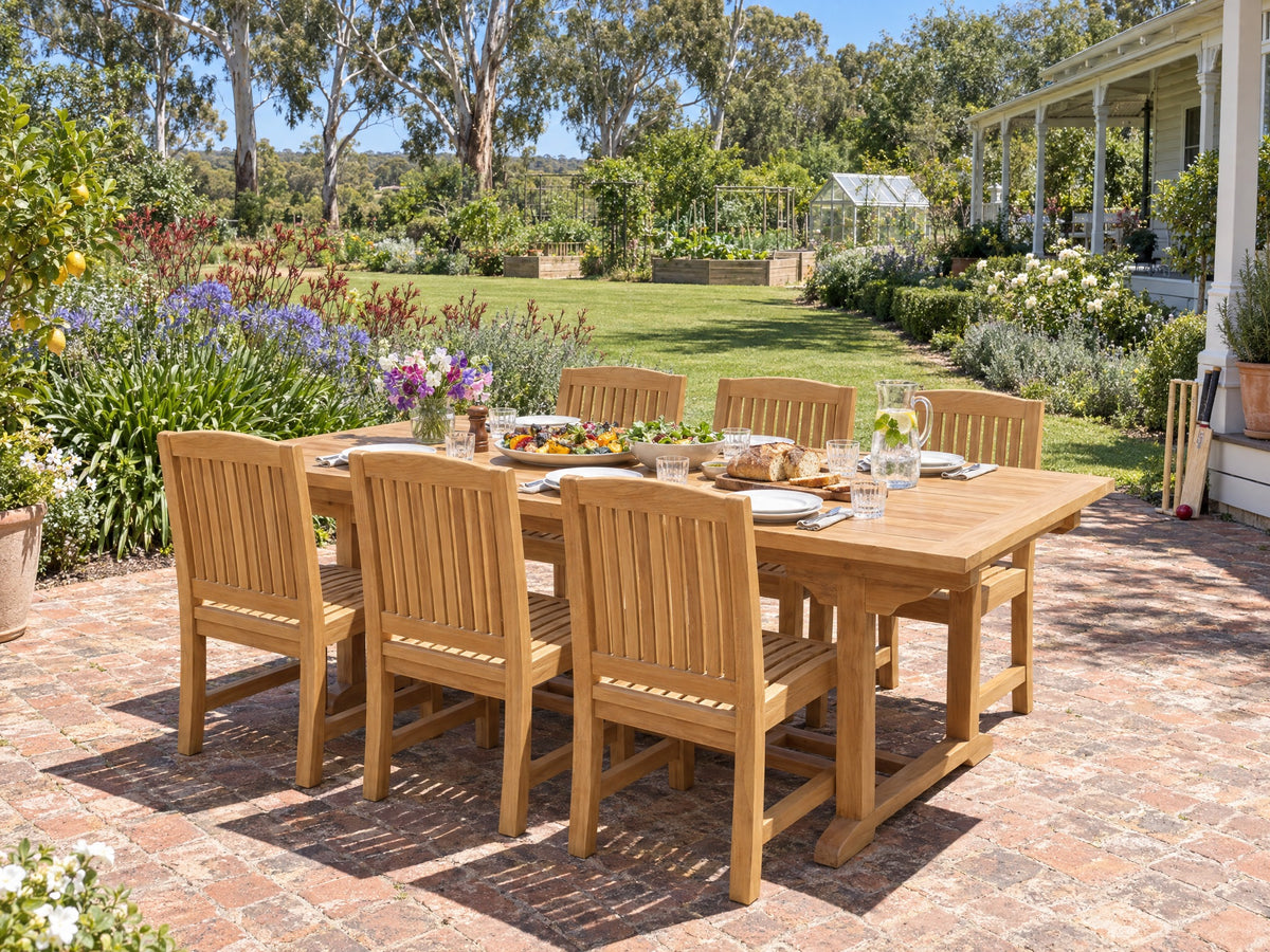 Teak Japan dining chairs around a teak Emma dining table set for lunch on a brick terrace