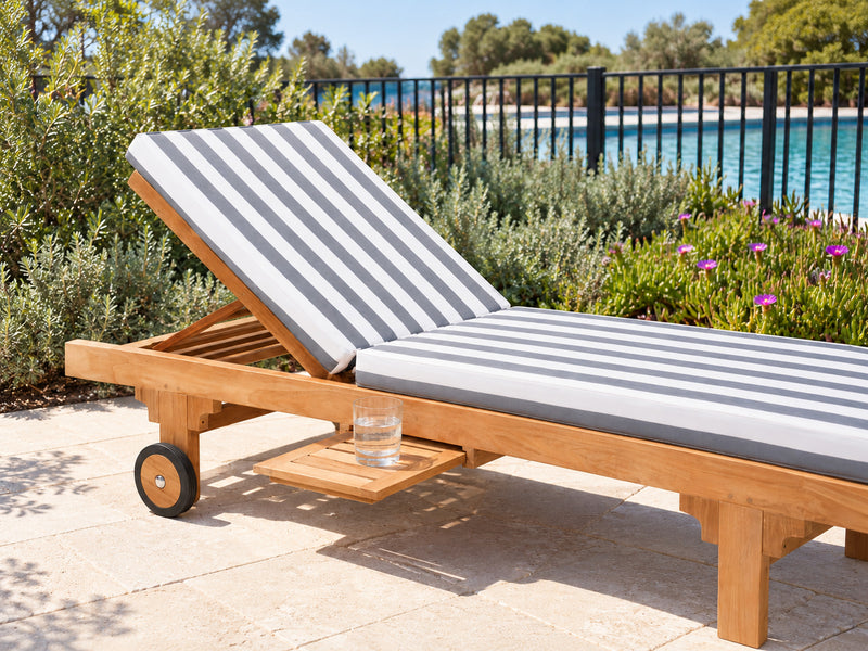 Close view of the retractable timber drink tray on a Traditional teak pool lounge, with a glass of water on it