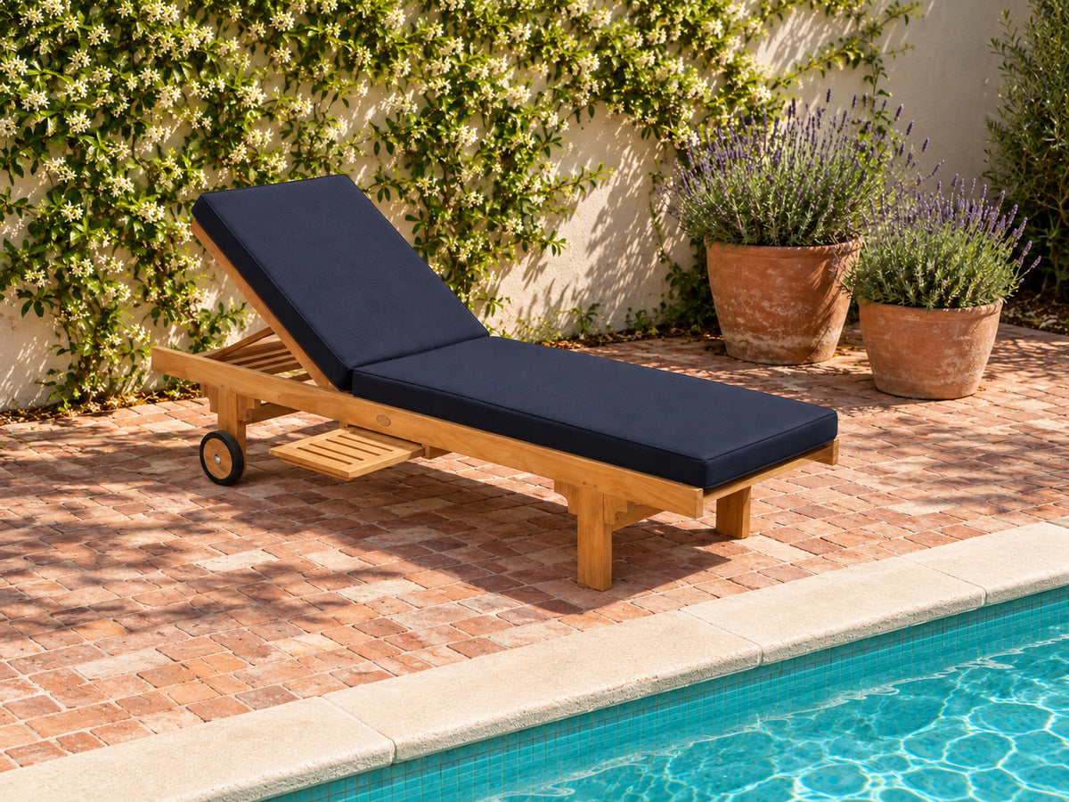 Traditional teak pool lounge with a navy cushion on brick paving in a walled courtyard
