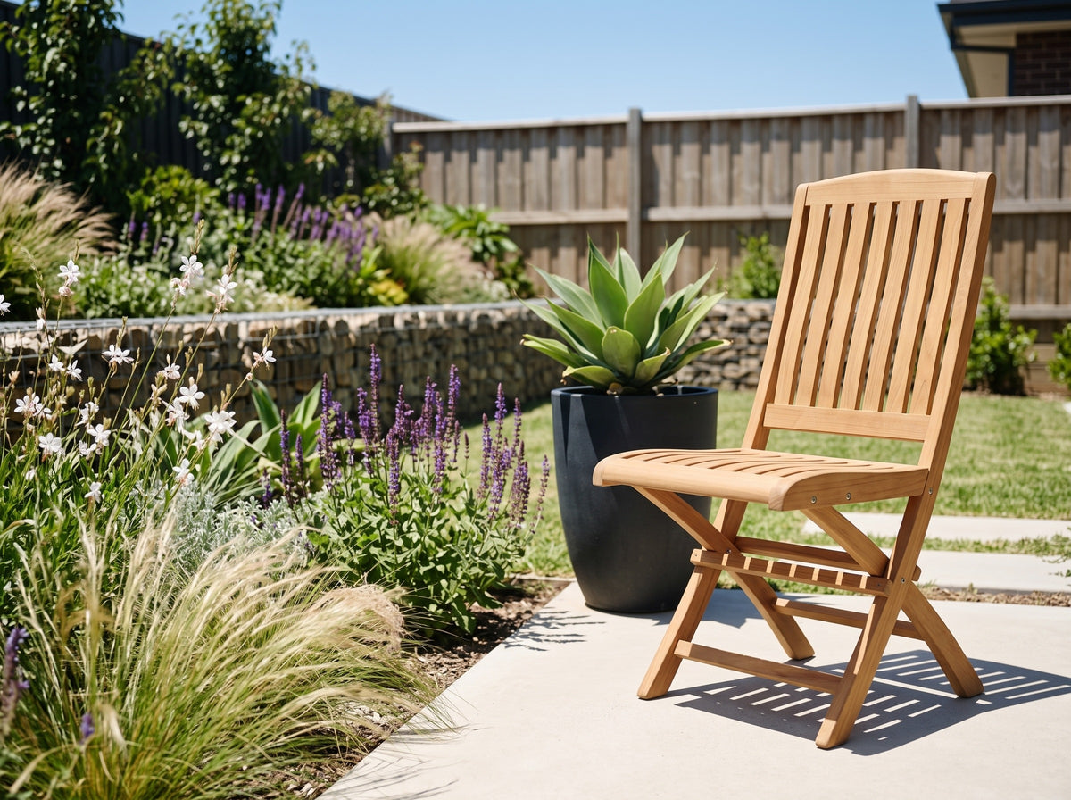 Teak Vivienne folding chair on a sunny path in a modern Australian garden with ornamental grasses and agave