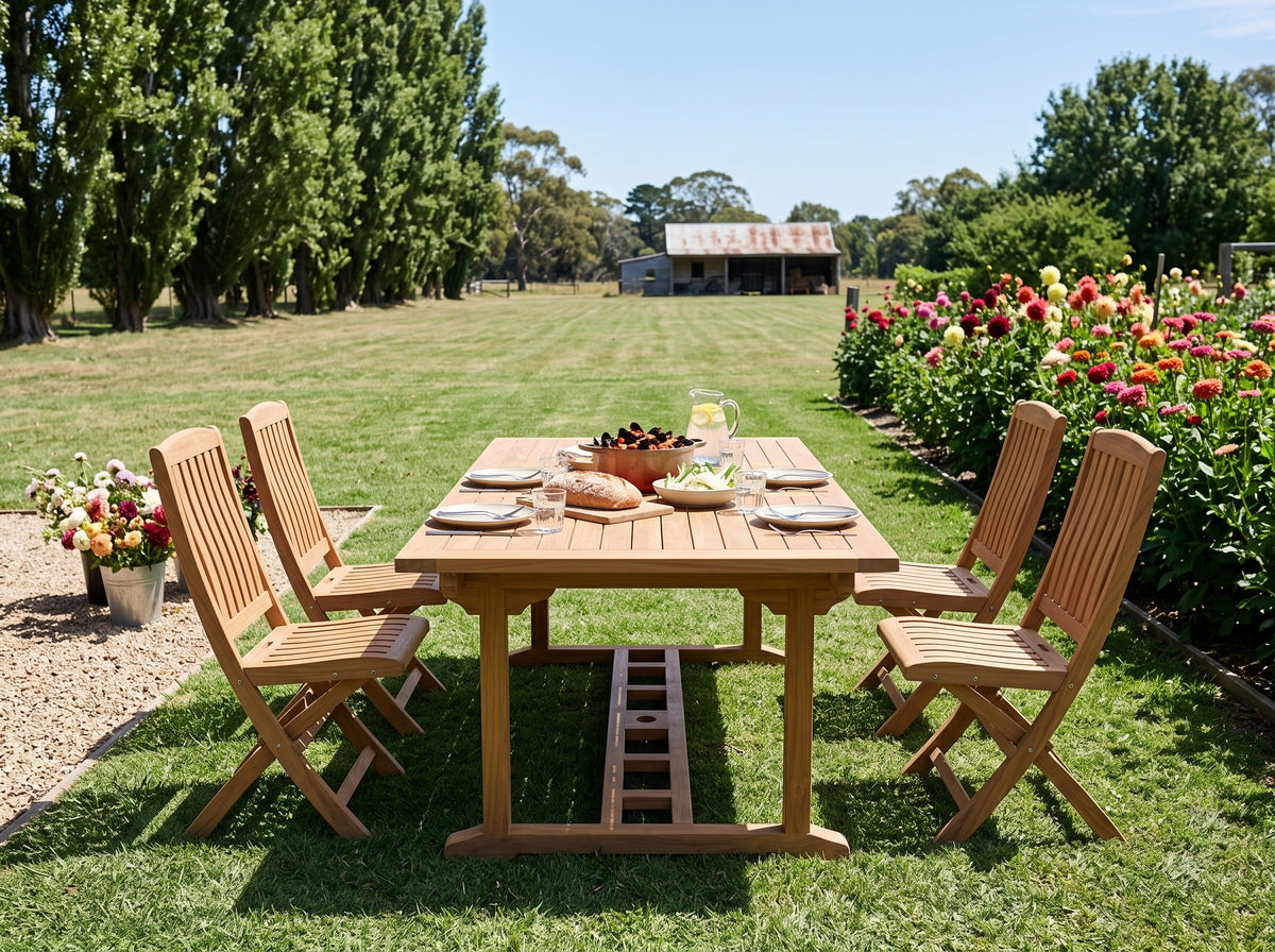 Teak Vivienne folding chairs around a teak Emma dining table on a country garden lawn